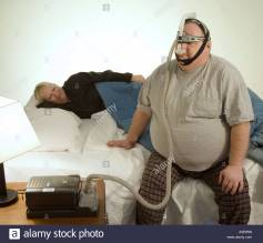 man-with-sleep-apnea-problems-readies-for-bed-as-his-wife-tries-to-A3E9RN